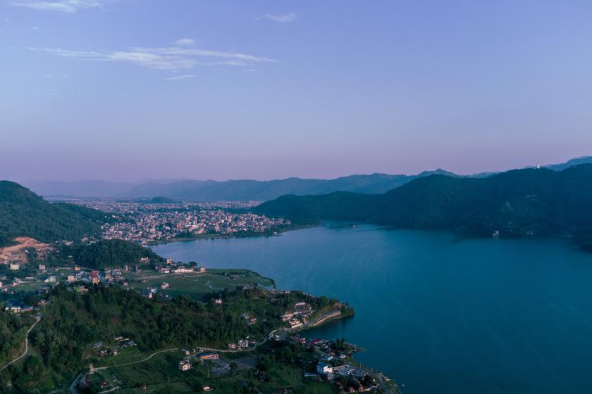  Nepálske mesto Pokhara ležiace pri jazere Phewa v okolí s hornatými kopcami. 
