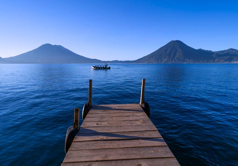 Jazero Atitlán, drevené mólo a sopečné vrchy. Guatemala. Foto: unsplash.com