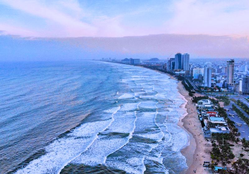 Pobrežné mesto s domami a pekná dlhá pláž mesta Da Nang.