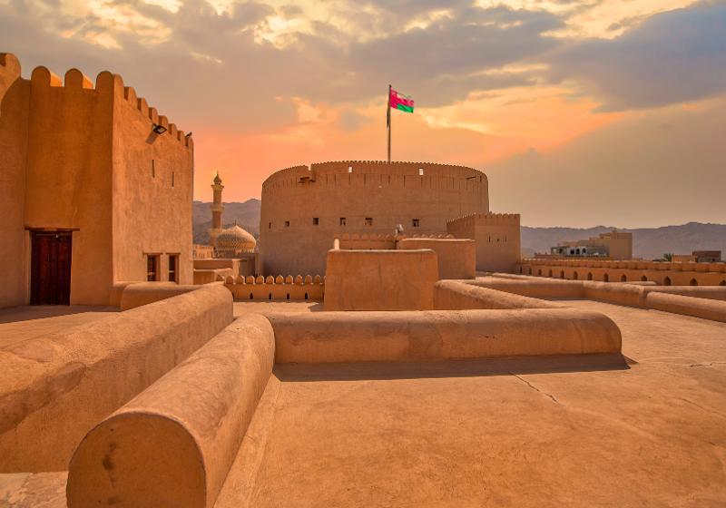 Pevnosť Nizwa s ománskou vlajkou. Omán. Foto: adobe.com