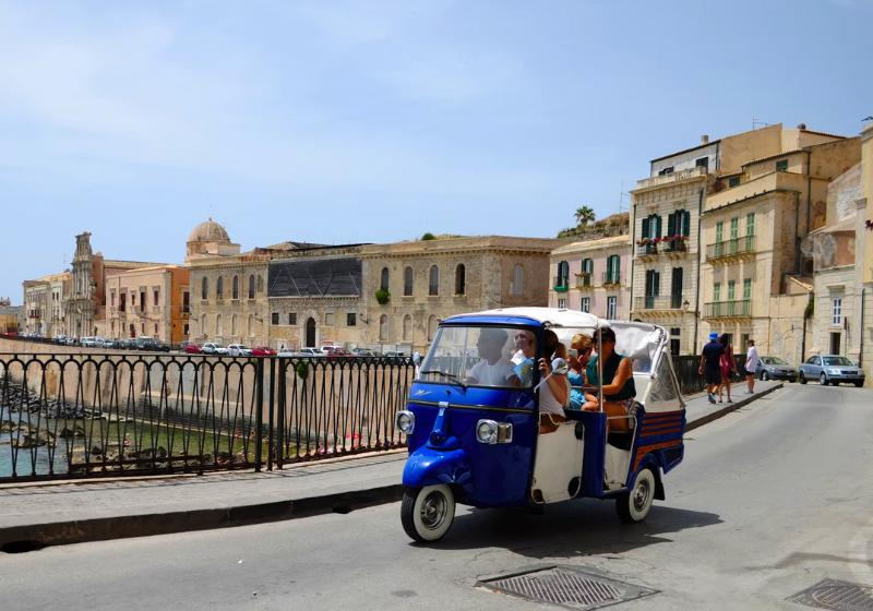 Tok tok na ceste s ľudmi a mesto Syrakúzy