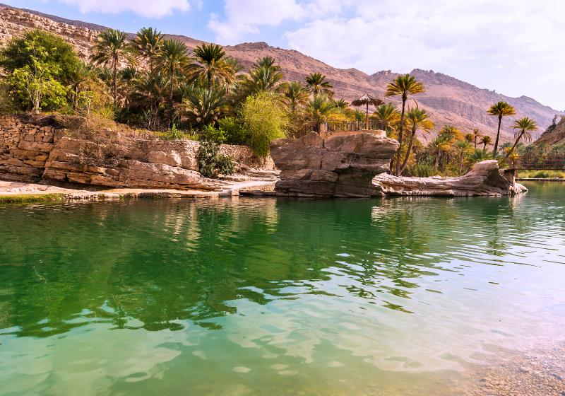 Sladkovodné jazero, palmy a skalný masív vo Wadi Bani Khalid, Omán. Foto: adobe.com