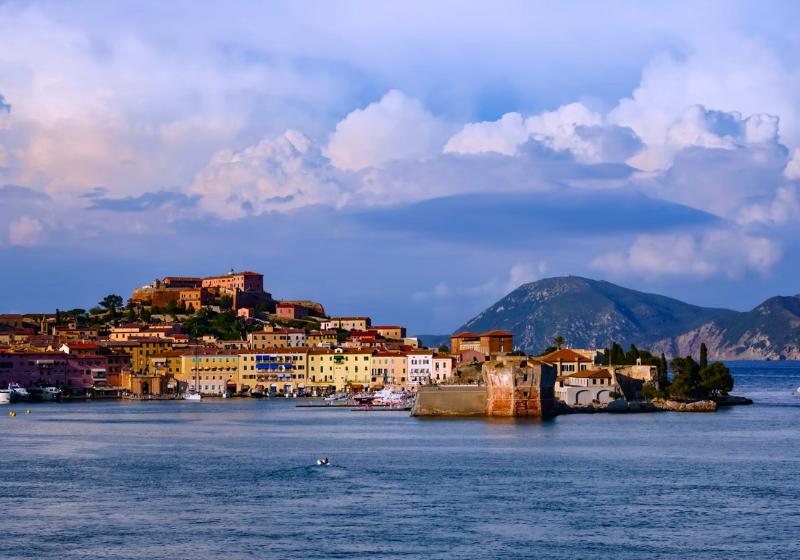 Morský prístav, mesto na kopci a pevnosť, hory v pozadí. Elba. Taliansko. Foto: unsplash.com