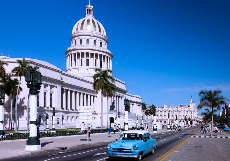 Biela budova, modré auto v Havane, Kuba. Foto: unsplash.com