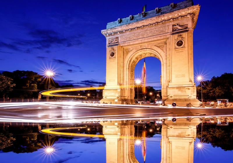 Vysvietený Triumfálny oblúk po západe slnka v Bukurešti, Rumunsko