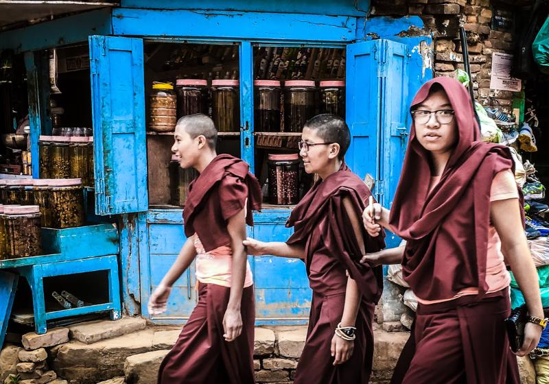 Traja kňazi odetí do hnedého odevu v Nepále na trhu. Foto: unsplash.com