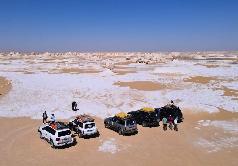 Biela púšť v kontraste s pieskovými dunami a džípmi. Egypt. Foto: unsplash.com